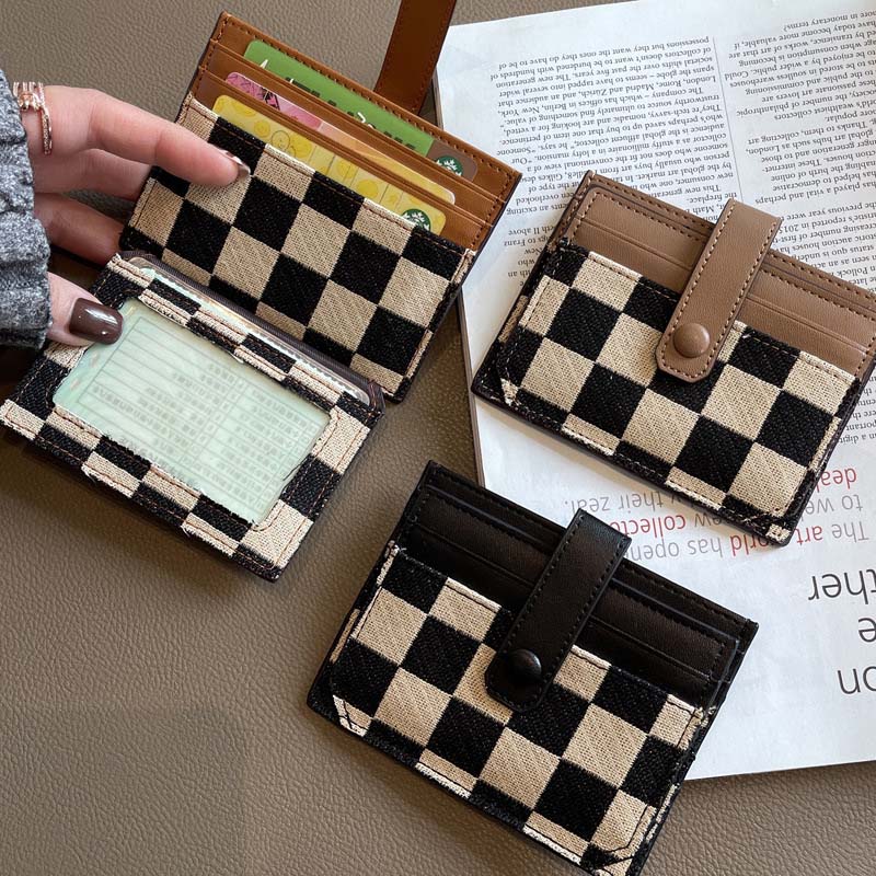 Detail of Women's plaid colorblock compact wallet, showing the checkered pattern and contrasting colors