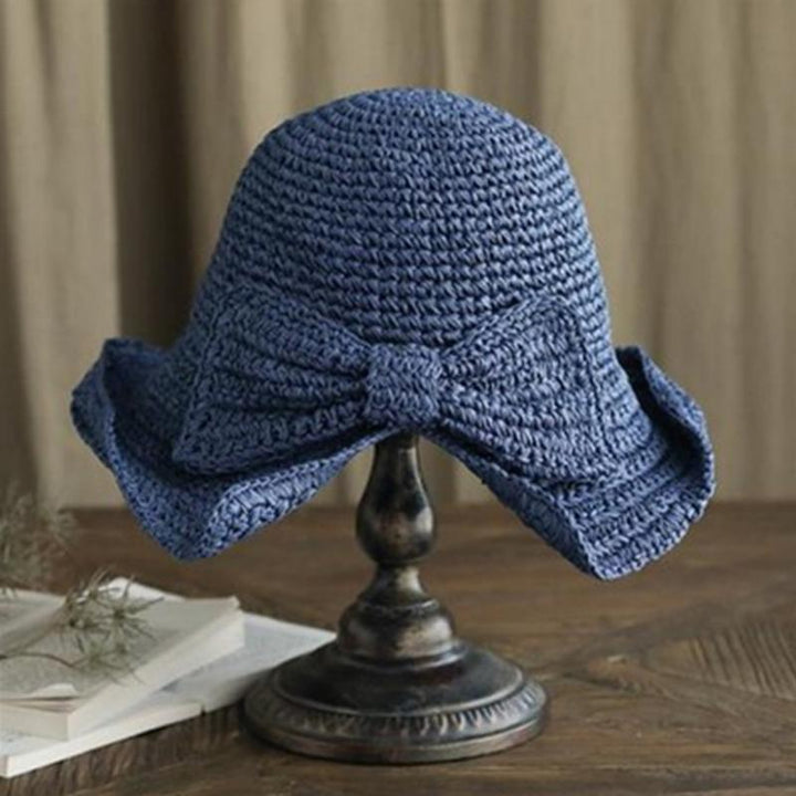 Feminine wide-brim sun hat with sophisticated bow, essential for summer fashion and UV care