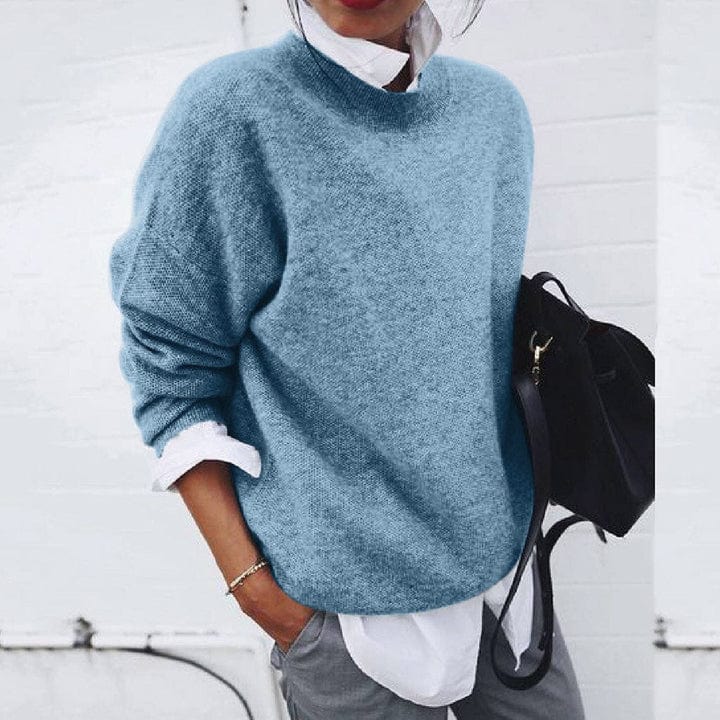 Model wearing a comfortable women's round neck pullover sweater in cream, showcasing casual style.
