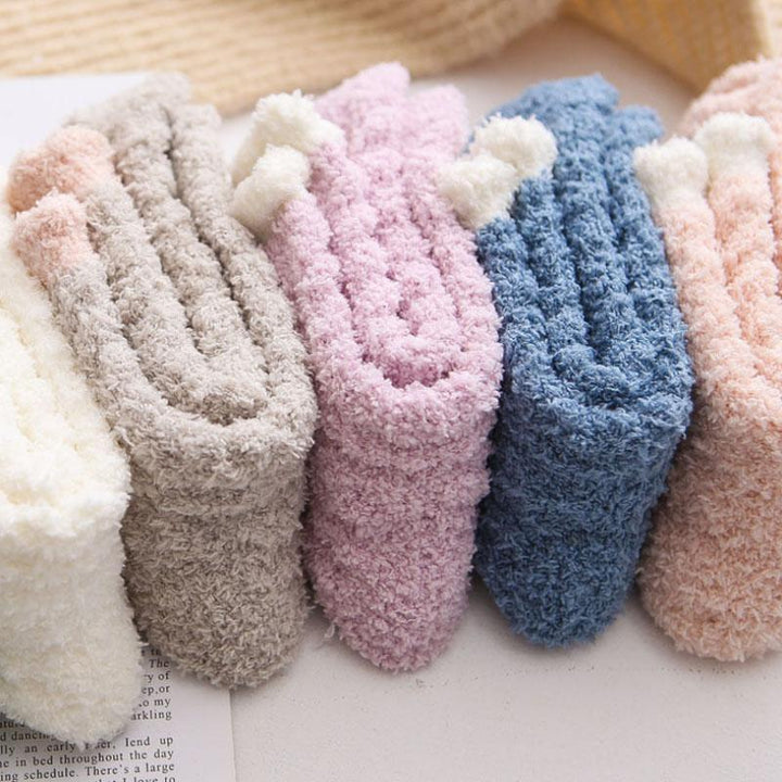 Lifestyle image of women's thermal winter socks keeping feet warm by a fireplace.