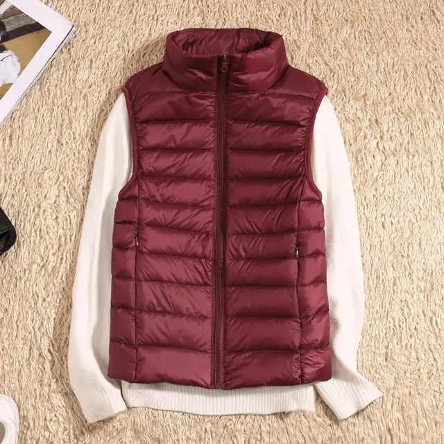 Women's lightweight down vest in vibrant teal, great for outdoor activities. Warm & flexible sleeveless jacket.