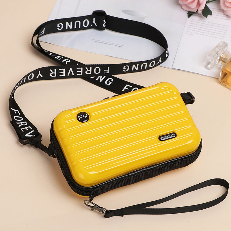 Women's mini suitcase crossbody bag in a vibrant color, attracting attention
