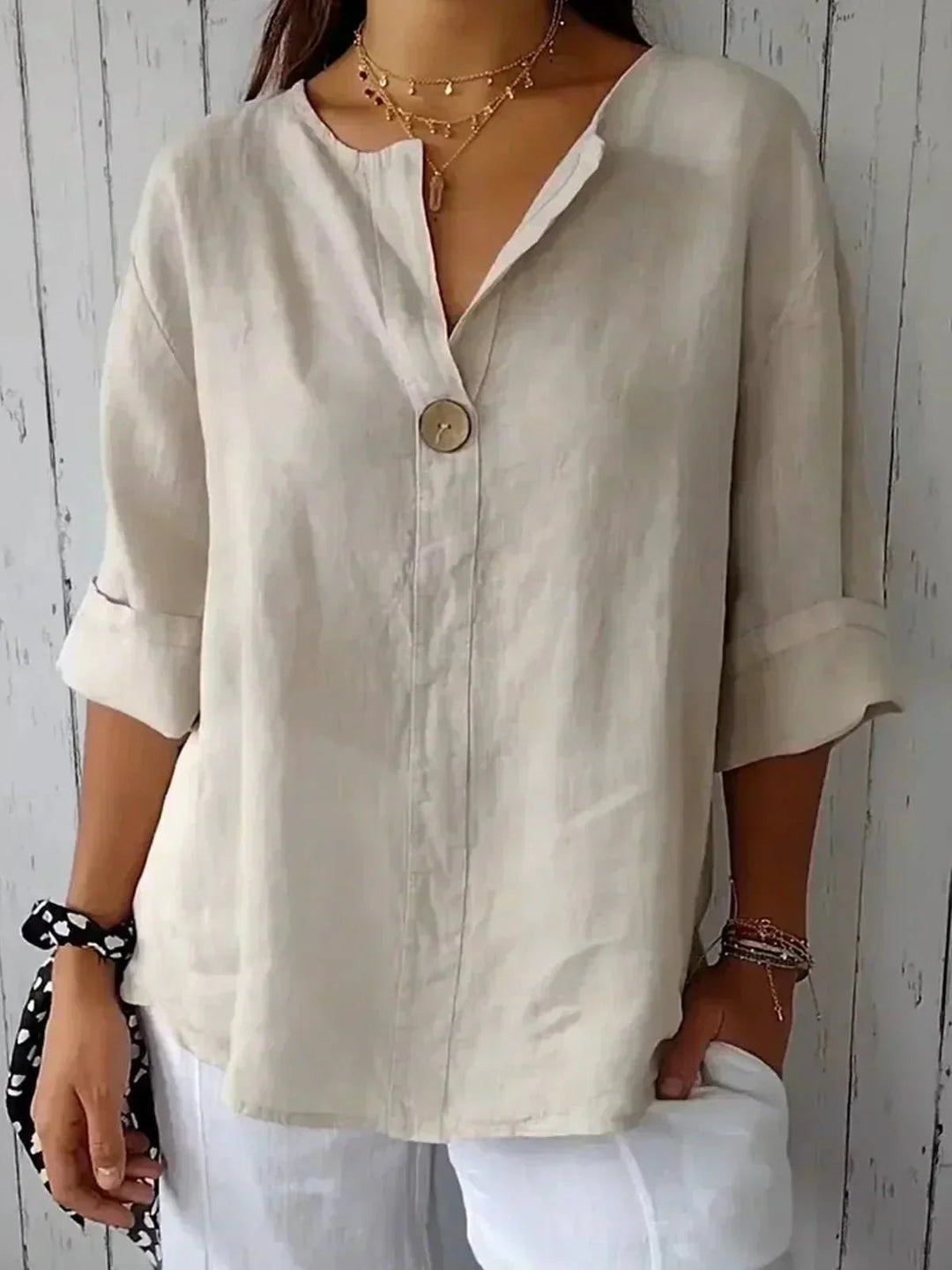 Casual women's V-neck button-down blouse with roll tab sleeves, perfect for summer fashion or travel.
