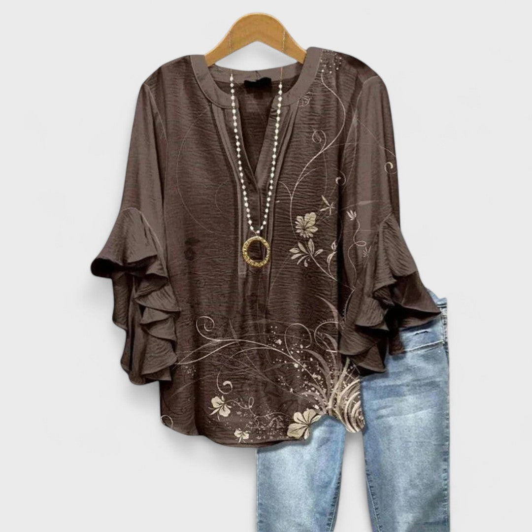 Loose fit patterned V-neck blouse with elegant ruffle sleeves, a fashionable women's top.