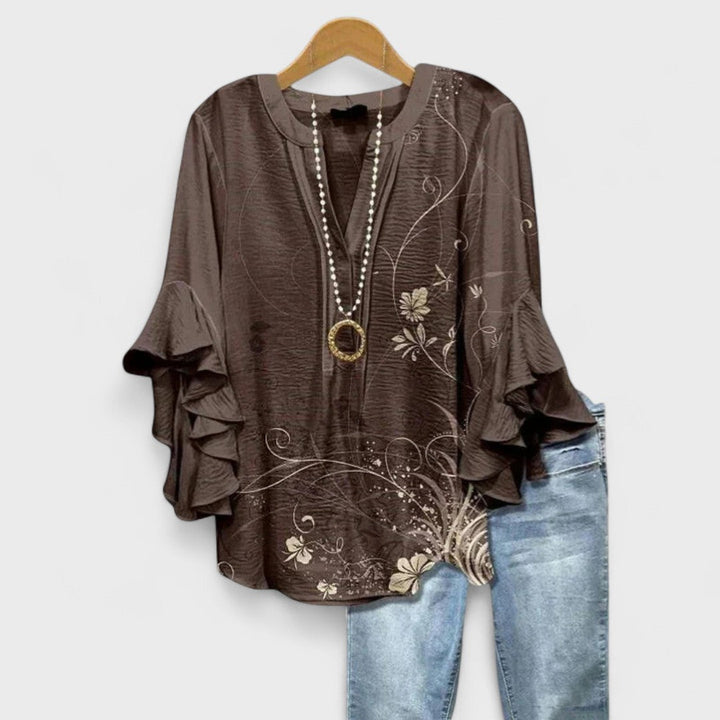 Loose fit patterned V-neck blouse with elegant ruffle sleeves, a fashionable women's top.