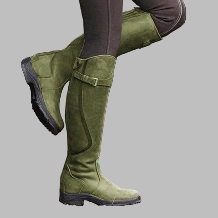 Durable women's riding boots for equestrian activities, waterproof, with a secure grip sole & comfortable adjustable fit.
