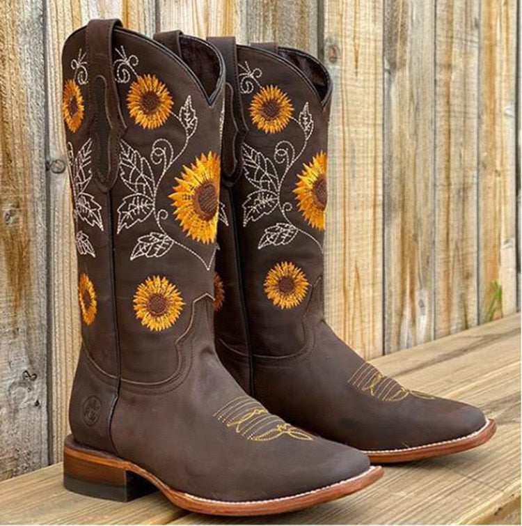 Close-up of elegant sunflower embroidered detail on women's mid-calf Western boots. Ideal for festival fashion.