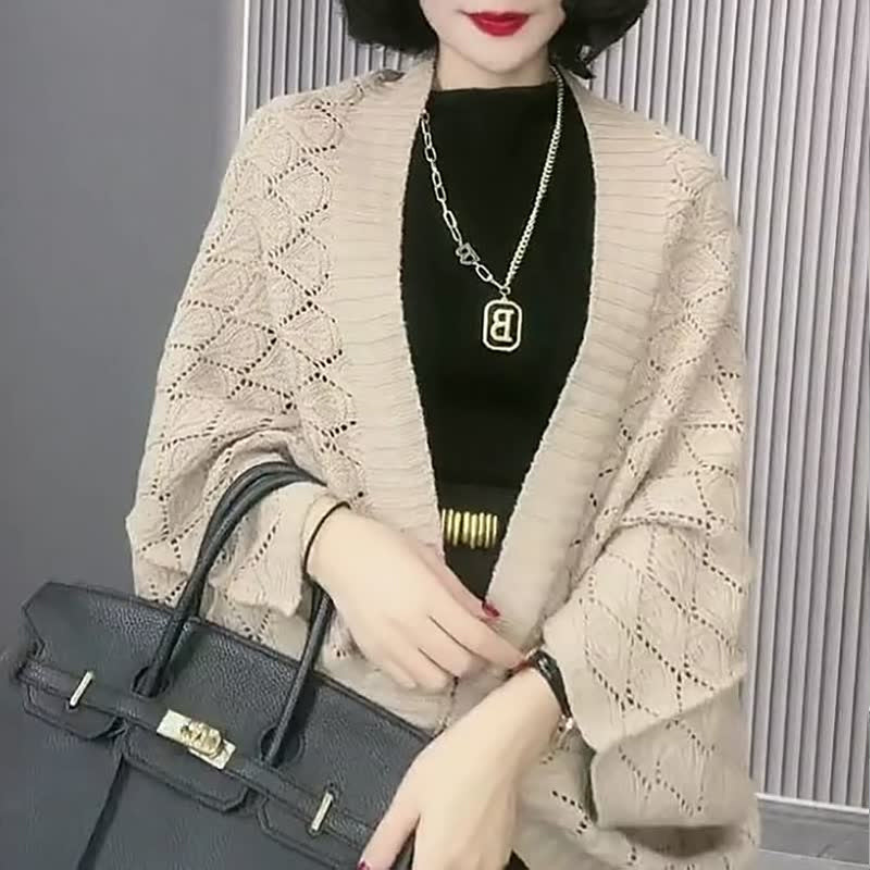 Model posing in a women's knit diamond hollow short cardigan, showcasing its flowy fit.
